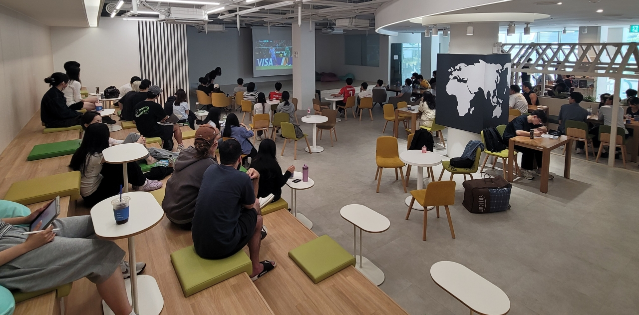 Students gathered around tables inside Sunglim Hall Global Lounge
